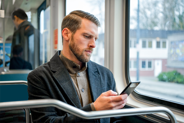 Man looking at phone while on train